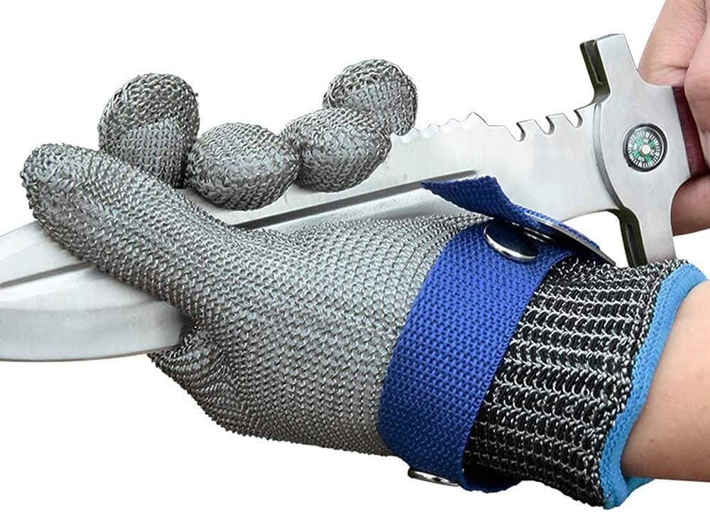 Metallic mesh glove with blue wristband being used to cut a white object.
