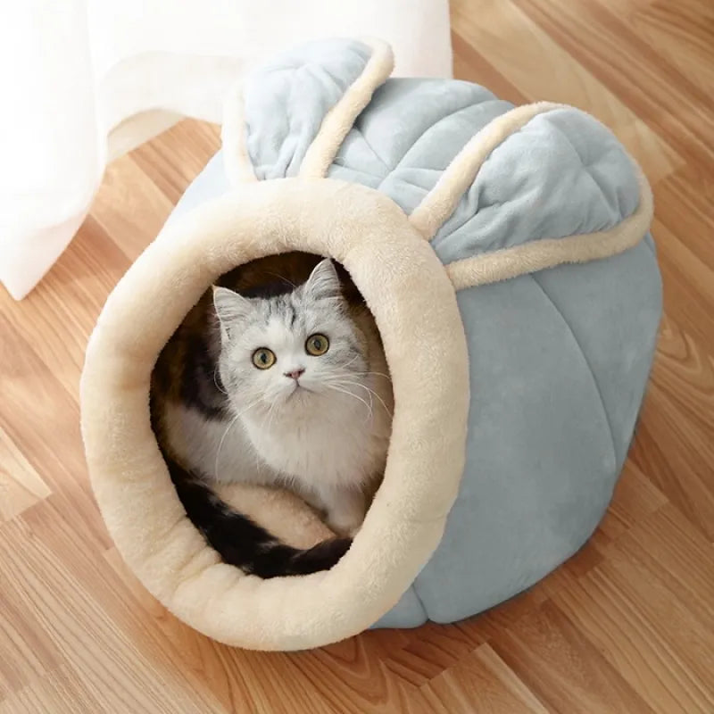 Cat inside a cozy gray and beige pet bed on a wooden floor