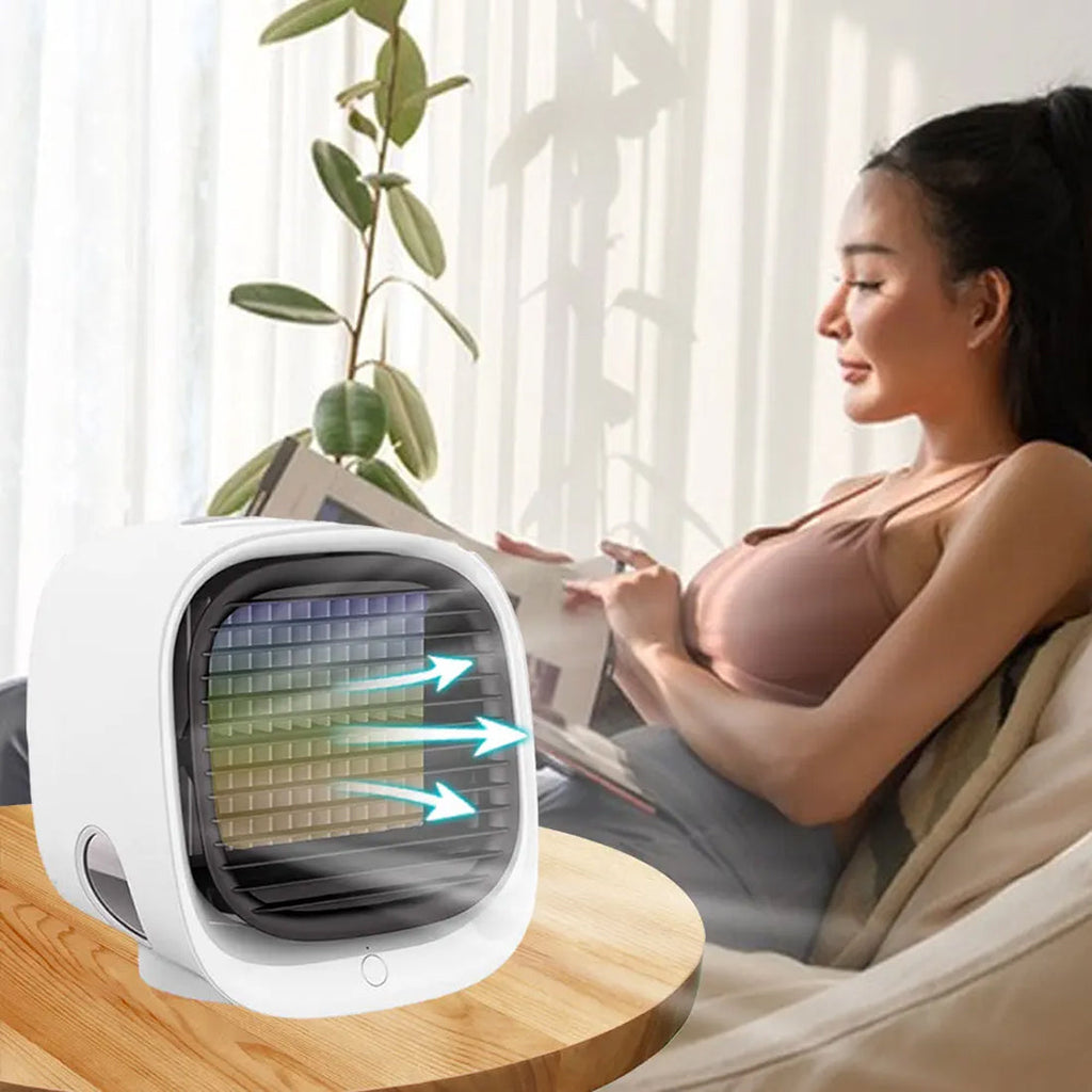Woman reading a newspaper next to a small air cooler in a bright room.
