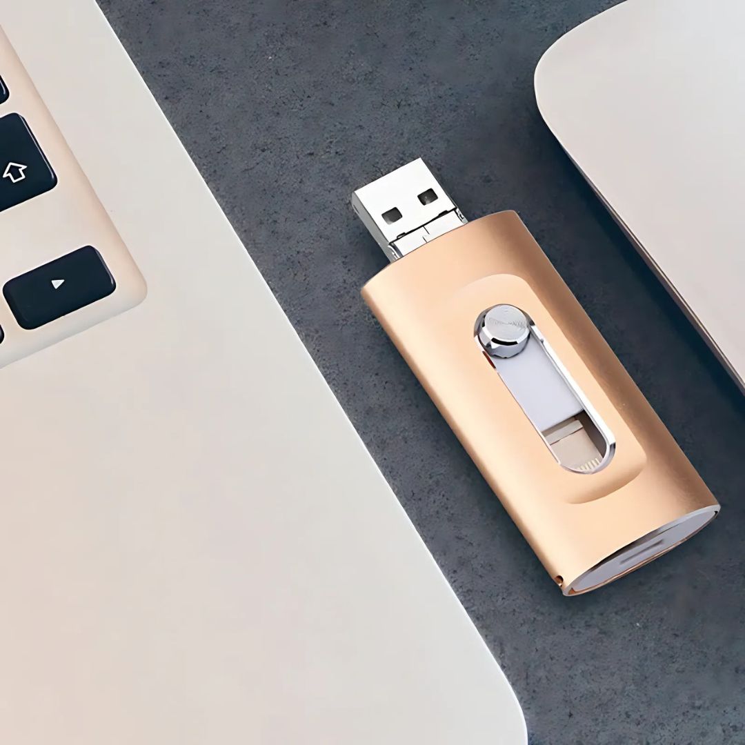Gold USB drive on a gray surface with a keyboard in the background