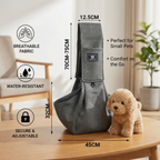 Gray pet sling with measurements and features on a wooden table, next to a small dog toy.