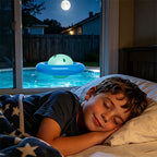 Child lying in bed with a glowing night light on a pool float outside the window at night.