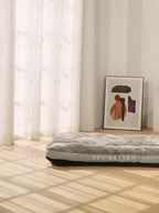 Pet bed with 'Pet Heaven' branding in a room with light-colored curtains and a framed picture on the wall.