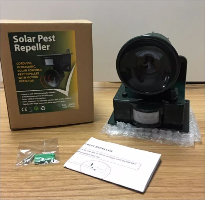 Solar pest repeller with packaging and accessories on a wooden surface