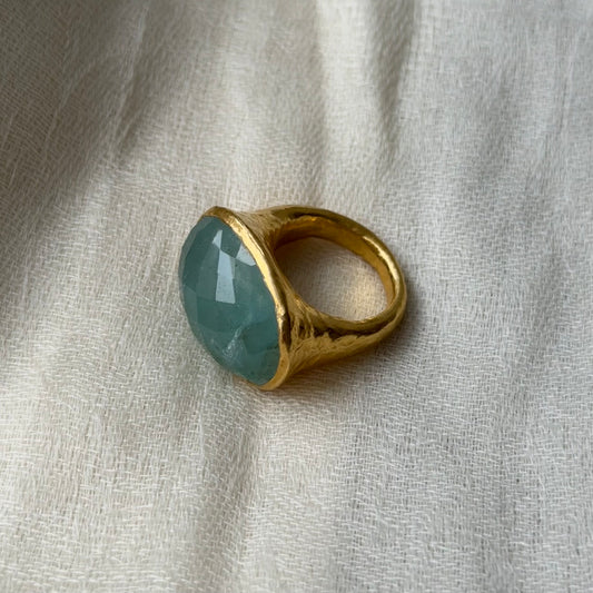 22ct solid Gold ring with a Aquamarine gemstone on a textured beige fabric background