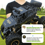 Person holding a large black remote control truck with text overlay on a grassy background
