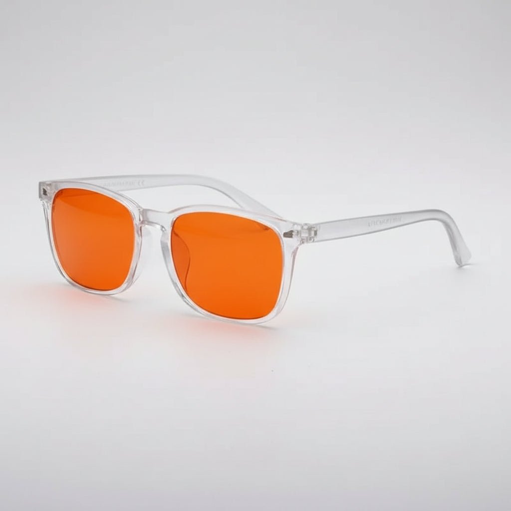 Sunglasses with orange lenses and clear frames on a light gray background