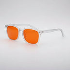 Sunglasses with orange lenses and clear frames on a light gray background