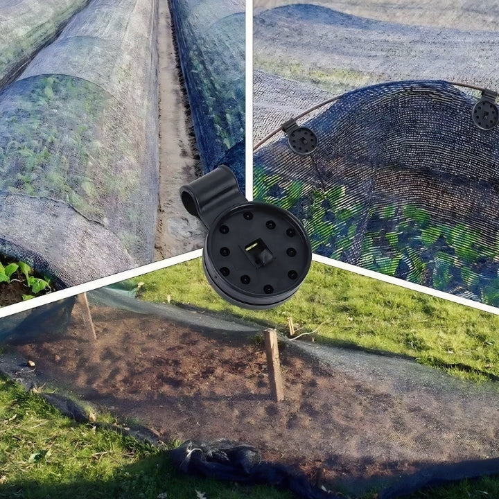 Close-up of a black garden hose nozzle with a background of green grass and a garden bed.