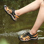 Person wearing outdoor sandals stepping into water with a natural background
