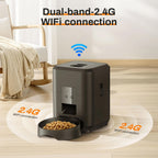 Black pet feeder with 2.4G WiFi connection on a light wood floor.