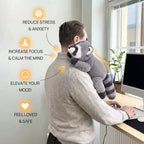 Person holding a raccoon plush toy while working at a desk with text benefits on a light background