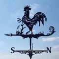 Metal weathervane with rooster design against a blue sky