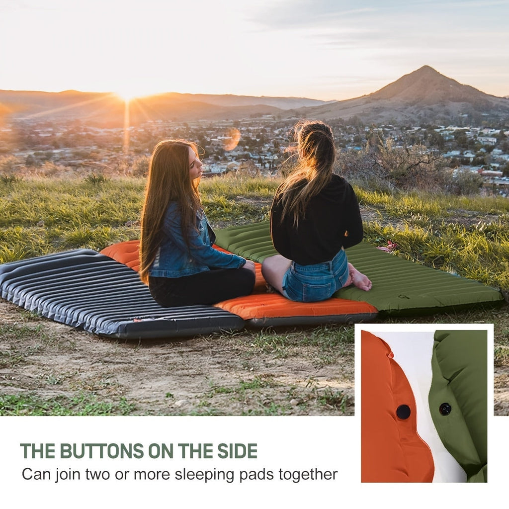 Two people sitting on a inflatable sleeping pad overlooking a scenic landscape with mountains and sunset.