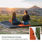 Two people sitting on a inflatable sleeping pad overlooking a scenic landscape with mountains and sunset.