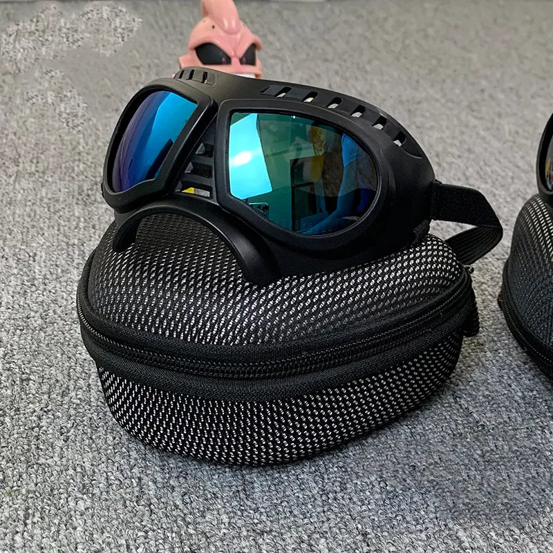 Black goggles with blue reflective lenses in a mesh carrying case on a gray surface.