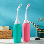 Two dental water flossers, one green and one pink, on a blue background.