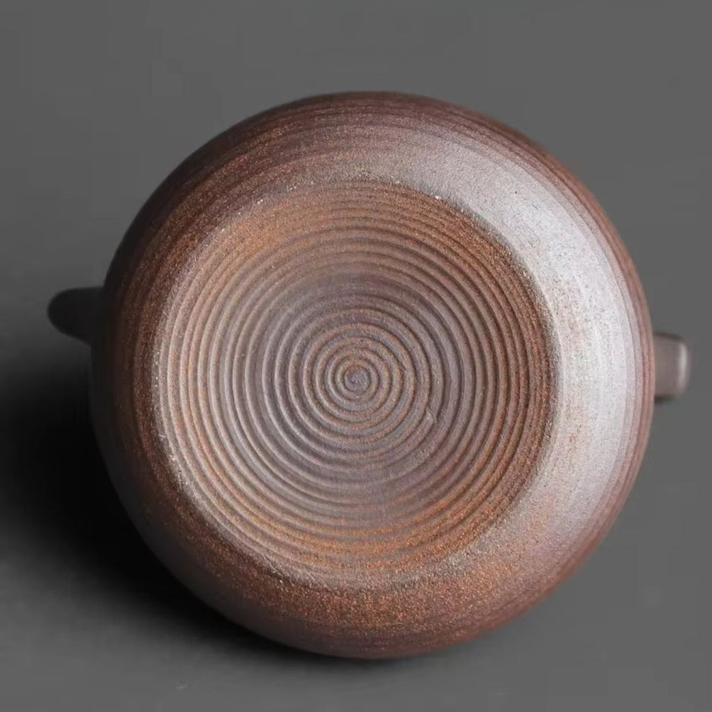 Close-up of a ceramic pot with concentric circle pattern on a dark background