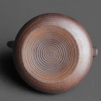 Close-up of a ceramic pot with concentric circle pattern on a dark background