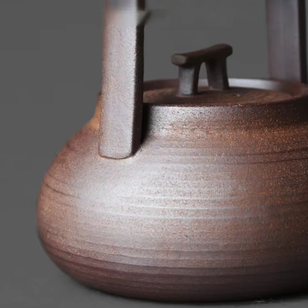 Close-up of a wooden teapot with a dark brown finish on a gray background