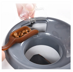 Gray pet food bowl with a brown scoop containing dog food, being filled by a hand.