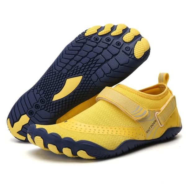 Yellow and navy water shoes with textured soles on a white background