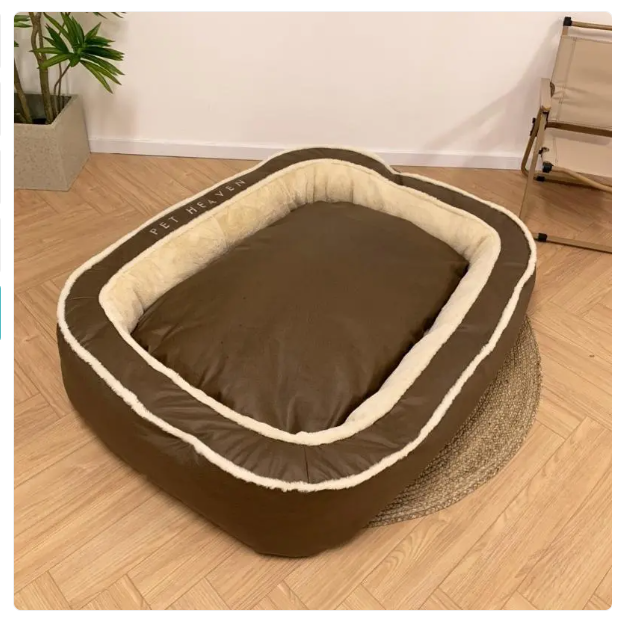 Brown pet bed with beige interior on a wooden floor
