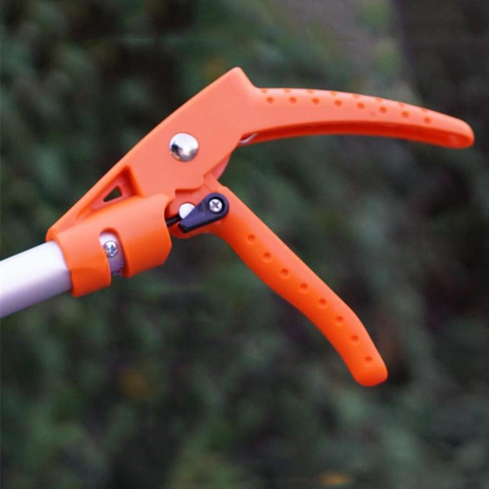Orange garden pruner tool against a blurred green background