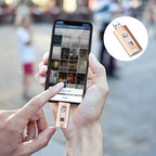 Person holding a smartphone with a USB drive attached, blurred background