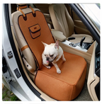 Dog sitting on a brown car seat cover inside a vehicle