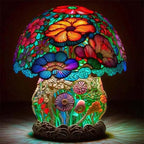 Colorful stained glass mushroom-shaped lamp with floral designs on a dark background