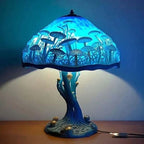 Decorative table lamp with a blue glass shade featuring mushroom design on a wooden surface.