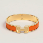 Gold and orange bracelet on a light gray background