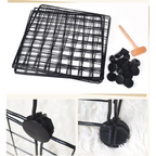 Black wire basket with clips and a wooden tool on a white background