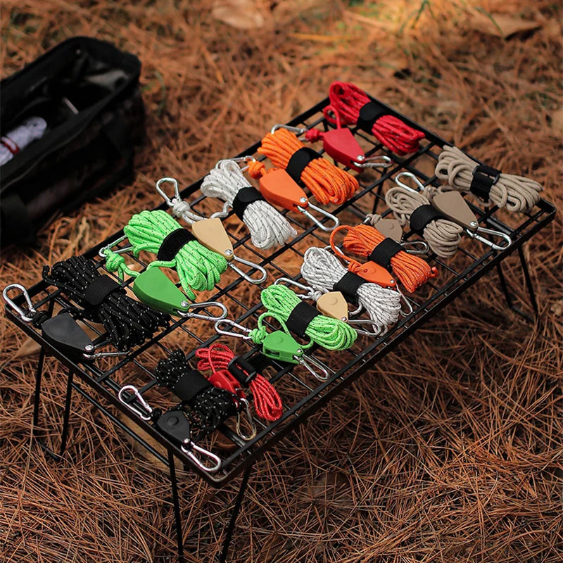 Set of colorful paracord ends on a metal rack with a background of dry grass.
