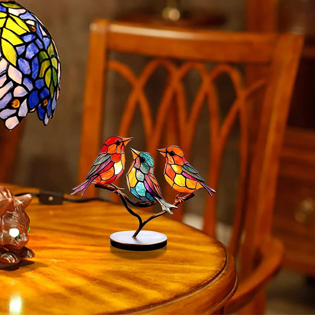 Colorful stained glass bird sculpture on a wooden table with a blurred background