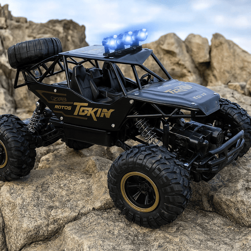 Black toy off-road vehicle with large wheels on rocky terrain, featuring the brand 'Tokin'.