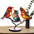 Colorful stained glass birds on a branch with a white background