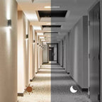 Corridor with light and dark lighting conditions, featuring doors and ceiling lights.