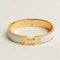 Gold and white bracelet on a light beige background