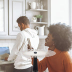 Woman using a wireless charging pad in a kitchen setting