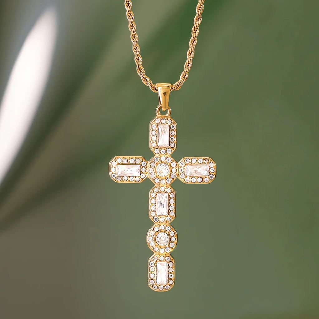 Gold cross pendant necklace on a green background