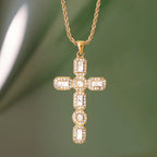 Gold cross pendant necklace on a green background