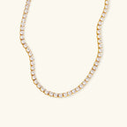 Gold necklace with clear stones on a white background