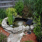 Small garden pond with solar panel and fountain in a natural setting