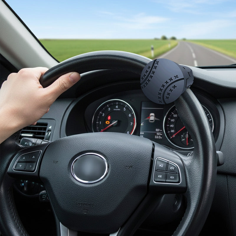 Steering wheel of a car with a hand on it, dashboard visible, and road outside.