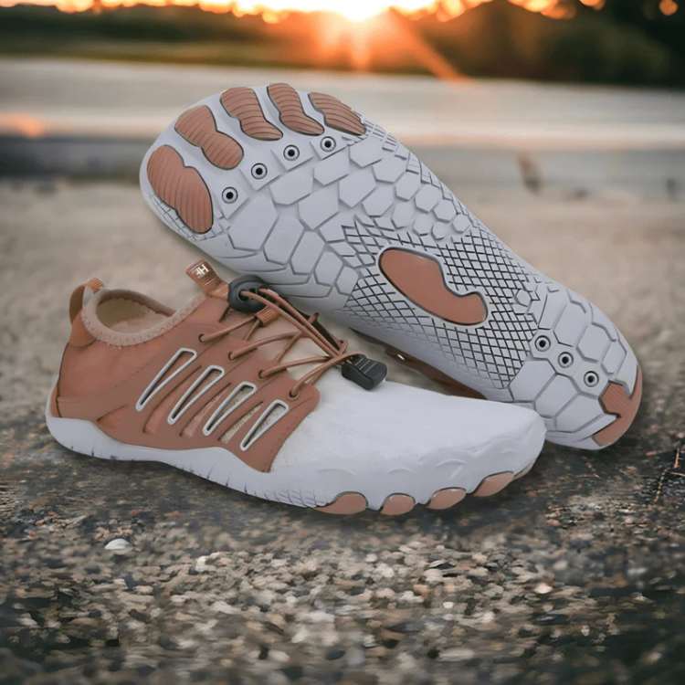 Pair of white and brown shoes on a concrete surface with a sunset in the background