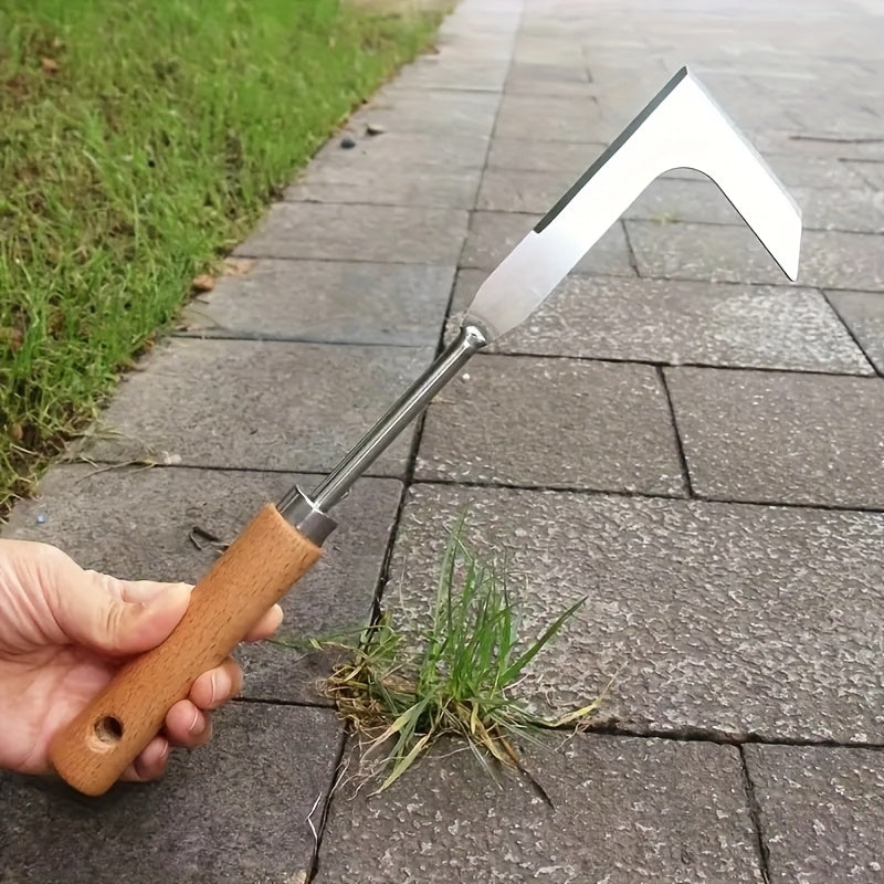 Hand holding a garden tool with grass being pulled from a crack on a pavement.