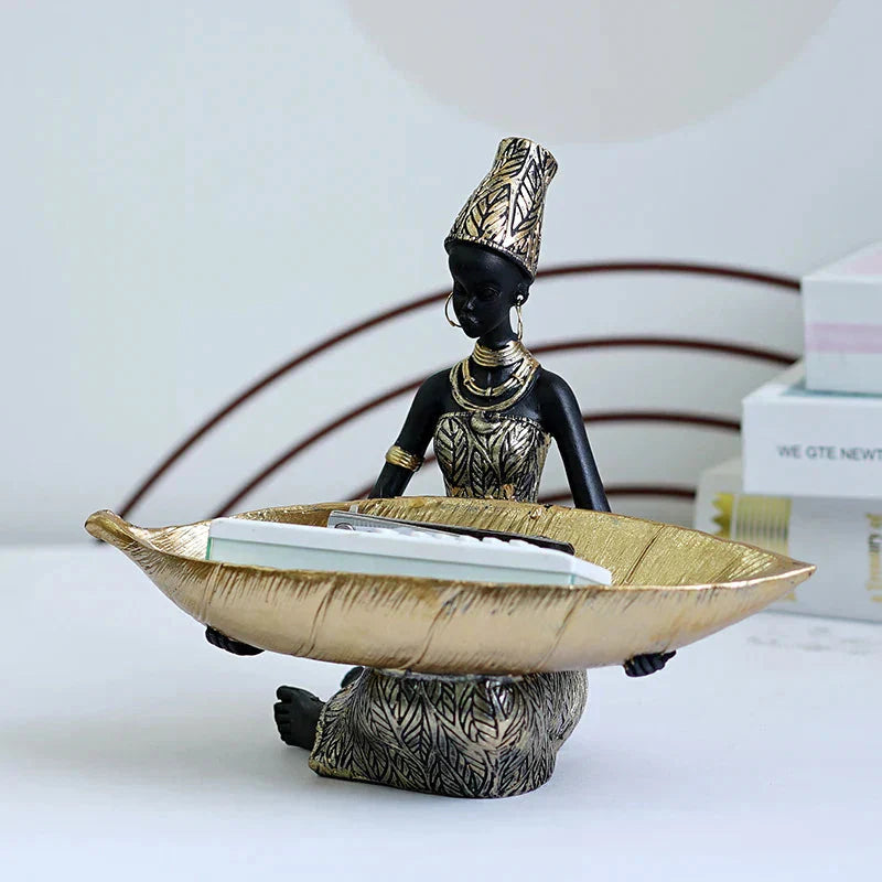 Decorative figurine with a bowl on a white surface