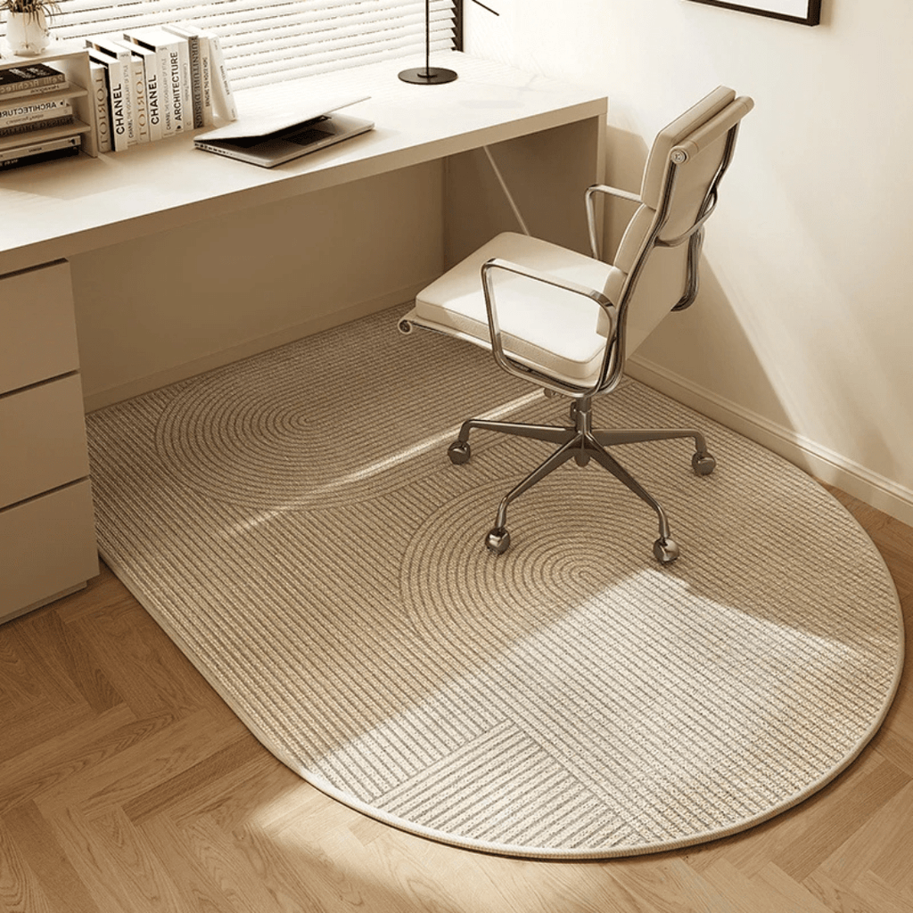 Round beige rug on a wooden floor in front of a desk with a chair.